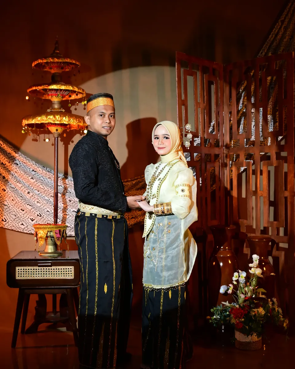 Indra dan Asdar berpose di pelaminan adat